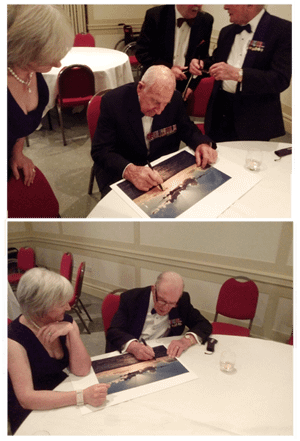 Men in dinner jackets signing prints